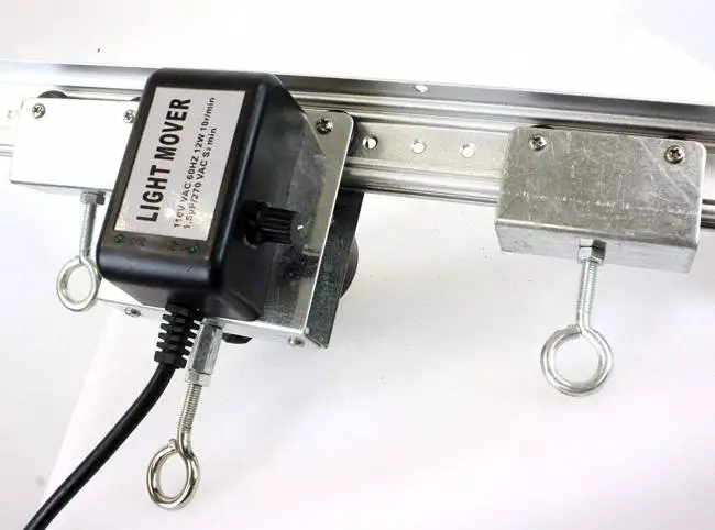 Close-up of a light mover system with a metallic rail, adjustable motor unit, and cables, vital for optimizing indoor plant lighting.
