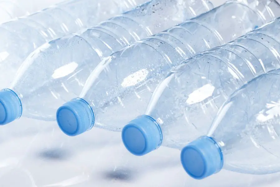 Empty plastic water bottles with blue caps, highlighting the issue of plastic waste.